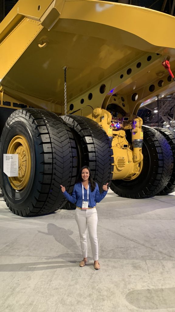 Alexis next to a giant dump truck for mining